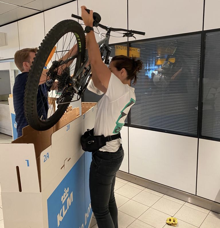 Ies en Ro laden een deels gedemonteerde fiets in een doos.